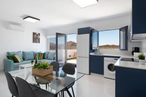 a kitchen and living room with a glass table and chairs at Brisa 3 in La Santa