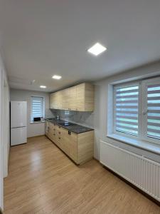 a kitchen with wooden cabinets and a white refrigerator at kambariu nuoma in Dovilai