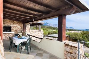 a patio with a table and chairs on a stone wall at Belvedere in San Teodoro