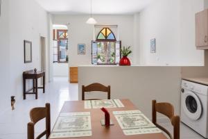 a kitchen with a table and chairs and a washing machine at Port House in Kos