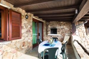 a table and chairs on a patio with a stone wall at Belvedere in San Teodoro