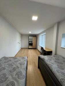 a bedroom with two beds and a desk in it at kambariu nuoma in Dovilai