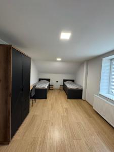 a room with two beds and a desk and a window at kambariu nuoma in Dovilai