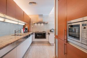 a large kitchen with wooden cabinets and a sink at Villa Agusmar in Llucmajor
