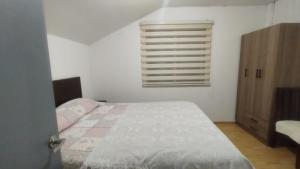 a white bedroom with a bed and a window at Casa Dichato Equipada in Tomé