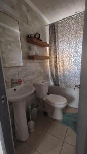 a bathroom with a toilet and a sink at Casa Dichato Equipada in Tomé