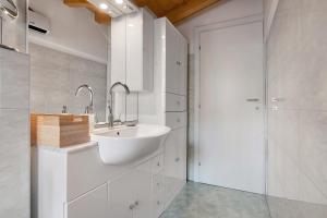 a white bathroom with a sink and a shower at Fogazzaro Lake View Apartment in Oria +32 photos