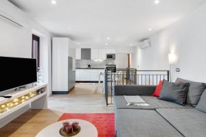 a living room with a couch and a tv at Fogazzaro Lake View Apartment in Oria