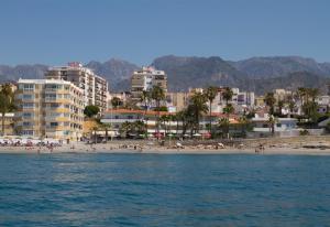 a beach with a bunch of people and buildings at Super Front Line Modern New Apartm in Nerja