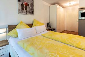 a bedroom with a bed with yellow sheets at Ferienwohnung Fetscher 2 in Reichenau +15 photos
