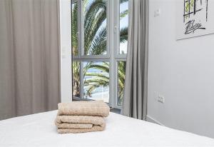 a bedroom with a bed with a window and towels at Super Front Line Modern New Apartm in Nerja +21 photos