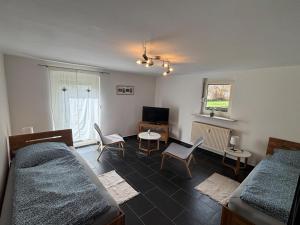 a bedroom with two beds and a table and chairs at Ferienapartment Dörfles-Esbach in Dörfles
