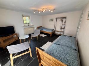 a room with a bed and a tv and a table at Ferienapartment Dörfles-Esbach in Dörfles