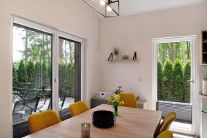 a dining room with a table with yellow chairs at Müritzblick in Vipperow