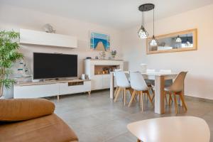 a living room with a tv and a table and chairs at Cambrils Platja in Cambrils