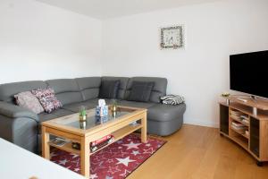 a living room with a gray couch and a coffee table at Aida in Überlingen