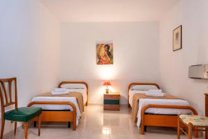 a room with three beds and a table and chairs at Il Baglio Antico in Prizzi