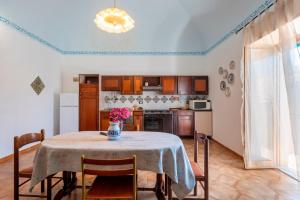 a kitchen with a table with a vase of flowers on it at Il Baglio Antico in Prizzi