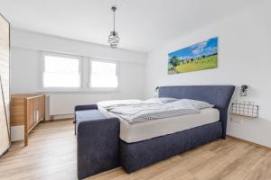 a bedroom with a blue bed in a white room at Haus Wanderglück in Schmallenberg +38 photos