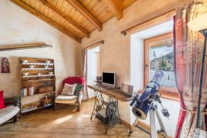 a room with a desk with a television and a window at Arpy an in Morgex