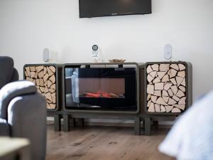 a tv with a fireplace in a living room at Haus Wanderglück in Schmallenberg