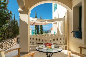 a patio with a table and chairs and an umbrella at Villa Millianna Exclusive Apartment in Kefallonia