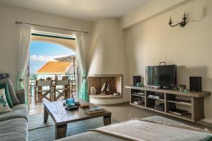a living room with a couch and a tv at Villa Millianna Exclusive Apartment in Kefallonia