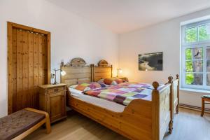 a bedroom with a wooden bed and a window at Ferienhof Schülp in Schülp