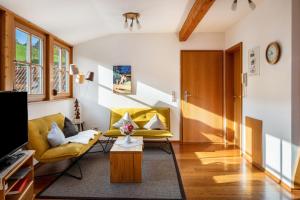 a living room with yellow chairs and a table at Ringlihof in Horben