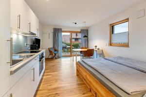 a bedroom with a large bed and a kitchen at Ferienwohnung Sonnenhalde in Moos