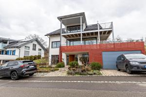 two cars parked in a parking lot in front of a house at Ferienwohnung Sonnenhalde in Moos