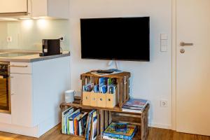a flat screen tv sitting on a wall in a kitchen at Ferienwohnung Sonnenhalde in Moos +12 photos