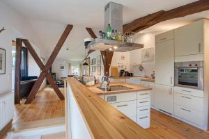 a kitchen with white cabinets and a wooden floor at Taubenkobel in Groß Wokern
