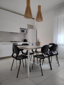 a white kitchen with a table and chairs at Apartment Mare Caorle int 1 in Caorle