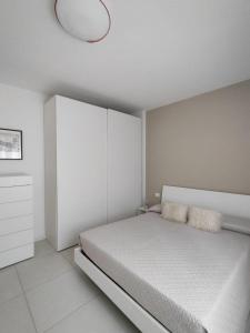 a white bedroom with a bed and a lamp at Apartment Mare Caorle int 1 in Caorle