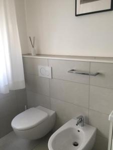 a white bathroom with a toilet and a sink at Apartment Mare Caorle int 1 in Caorle +7 photos