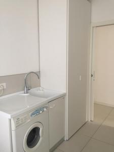 a laundry room with a washing machine and a sink at Apartment Mare Caorle int 1 in Caorle