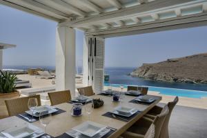a dining room with a table and a view of the ocean at Blueros - Sand Suite in Megas Gialos - Nites