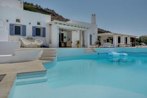 a villa with a swimming pool with blue water at Blueros - Sand Suite in Megas Gialos - Nites