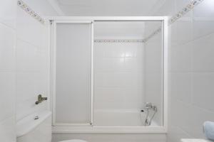 a white bathroom with a shower and a toilet at Bajamar - Apart-Piscina naturales in Bajamar +20 photos