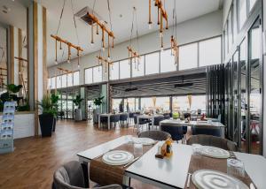 a restaurant with tables and chairs and windows at Nothern Cyprus Four Seasons Life Collection Apartments & Lofts Seafront in Ayios Dhometios