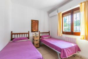 two beds in a room with two windows at Villa Margarita in Benissa +17 photos