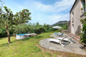 a patio with a chair and a table and an umbrella at Villa Nespolo in Levanto