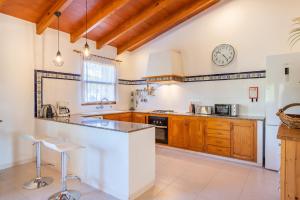 a kitchen with wooden cabinets and a clock on the wall at Els Garroverets in Binissalem