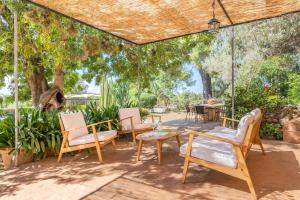 a patio with chairs and a table under a pergola at Els Garroverets in Binissalem