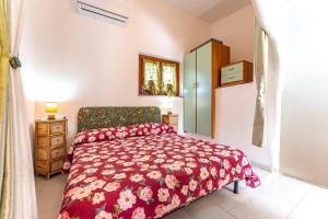 a bedroom with a bed with a red bedspread at Villa Alice in Villasimius