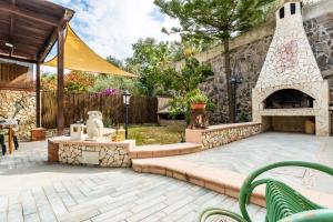 a backyard with a stone fireplace and a patio at Villa Alice in Villasimius