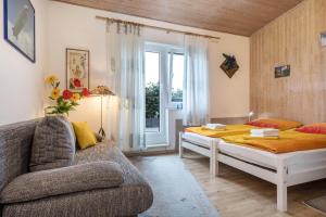 a bedroom with a bed and a couch and a window at B und E Röck in Meckenbeuren