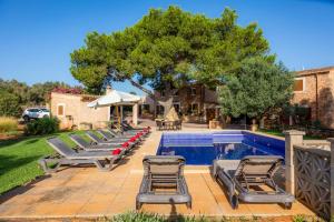 a row of lounge chairs next to a swimming pool at Ses Angoixes in Santanyi