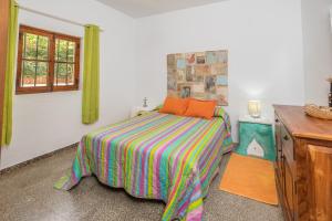 a bedroom with a bed with a colorful blanket at Casa de María in El Palmar